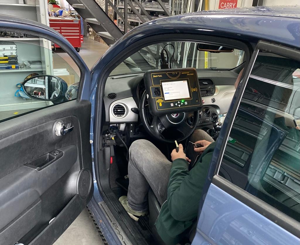 Monteur leert nieuwe autosleutel in via OBD stekker in de auto